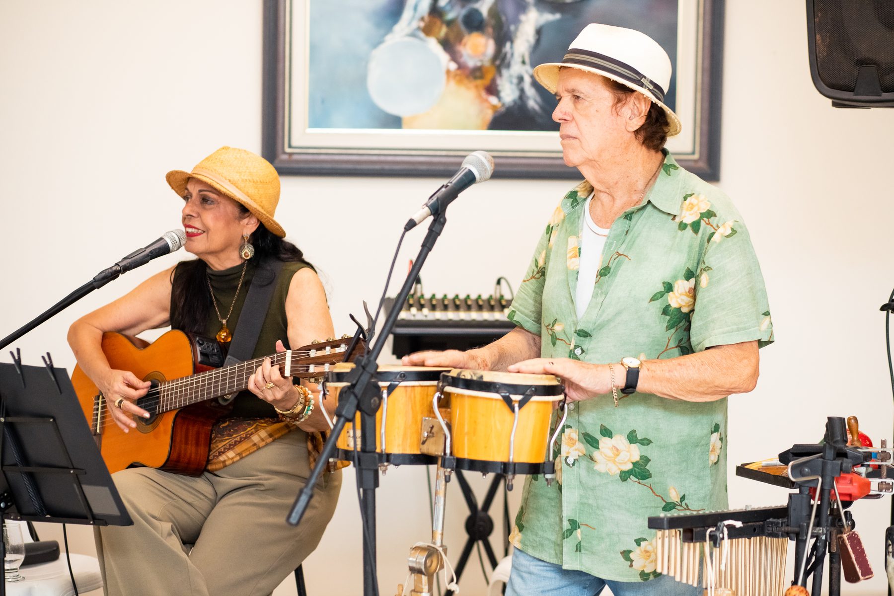 Waleska Santos ao violão e Nando Gomes nos bongôs, tocando numa festa
